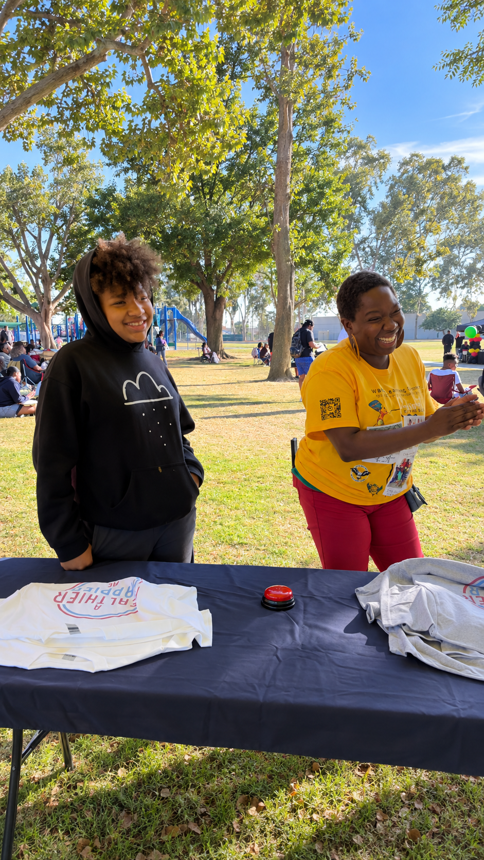 AHHM volunteer and student laughing at a wellness booth